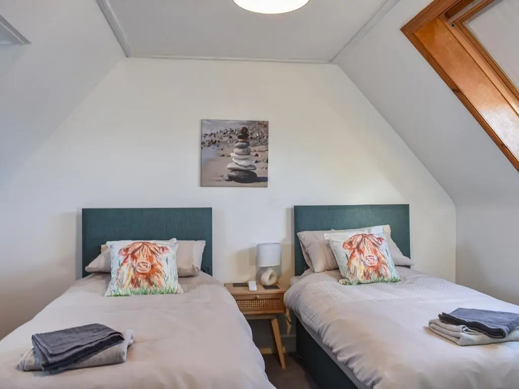 two beds in a room with white walls at Strathlene Lodge in Ianstown