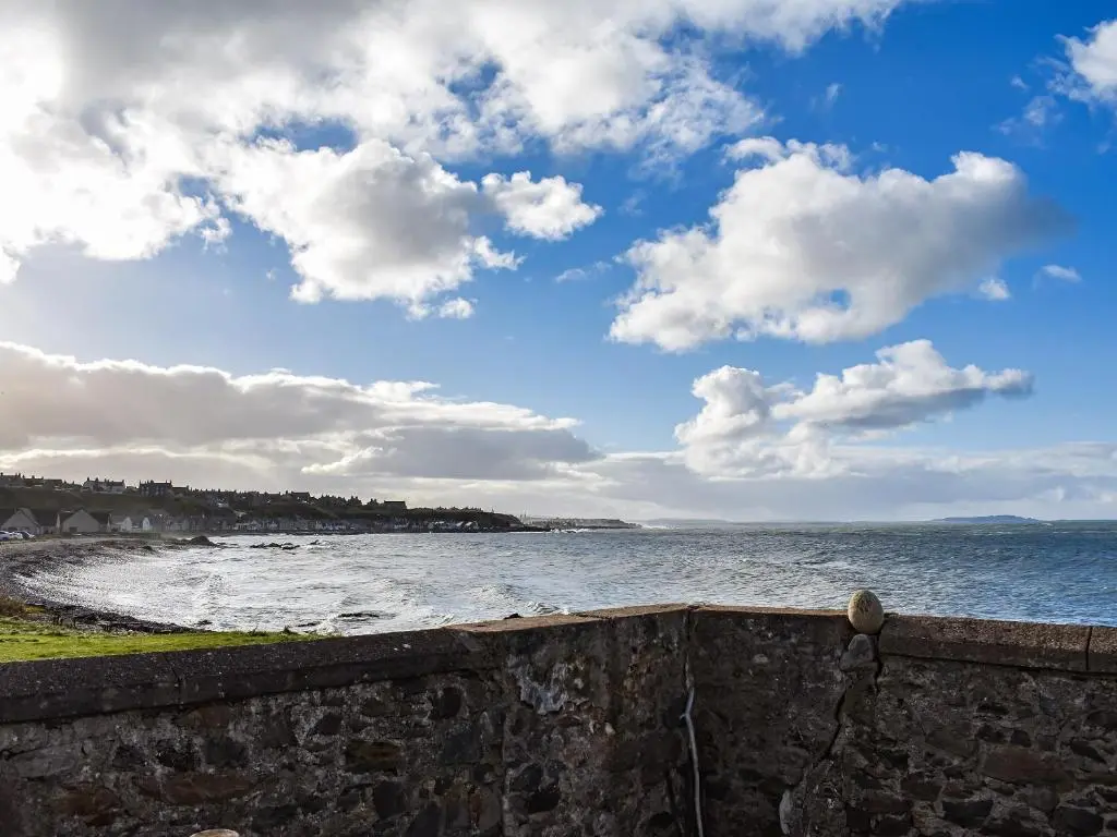 a view of the ocean from a stone wall at Strathlene Lodge in Ianstown