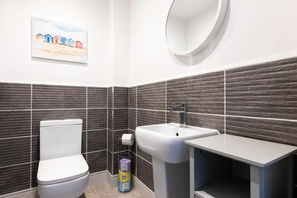 a bathroom with a toilet and a sink and a mirror at Fletcher's Gate in Inverness