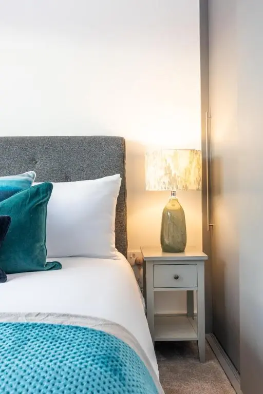 a bedroom with a bed and a nightstand with a lamp at Fletcher's Gate in Inverness