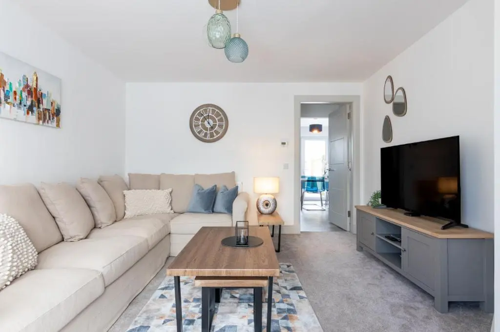 a living room with a white couch and a tv at Fletcher's Gate in Inverness
