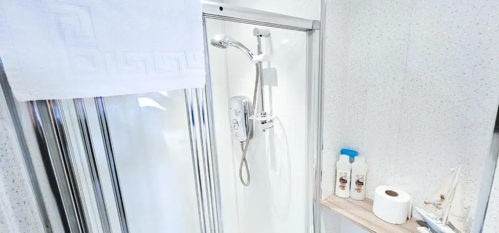 a shower with a glass door in a bathroom at mySTAYINN Kinloch 7 Bedroom House in Inverness