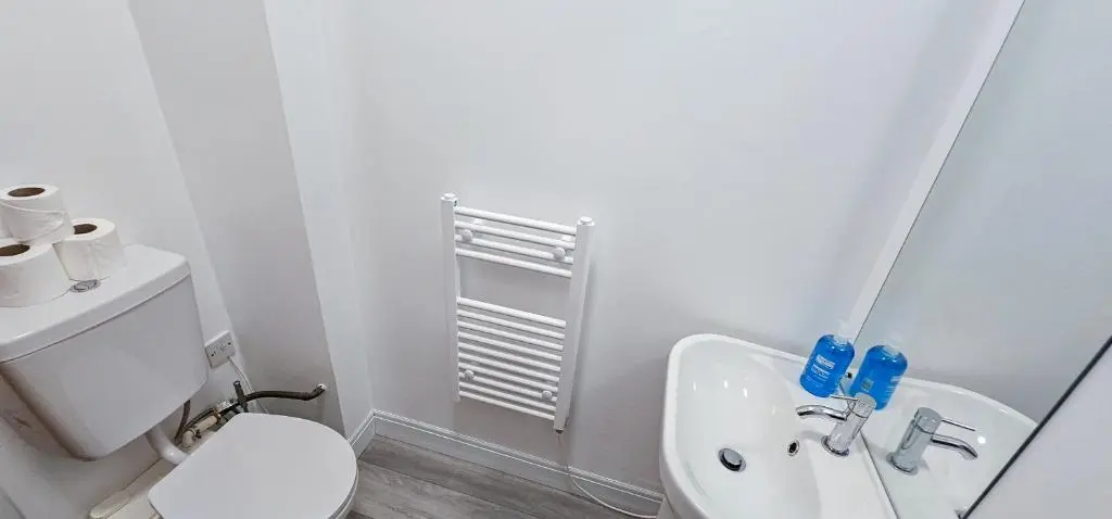 a white bathroom with a toilet and a sink at mySTAYINN Melrose Villa in Inverness