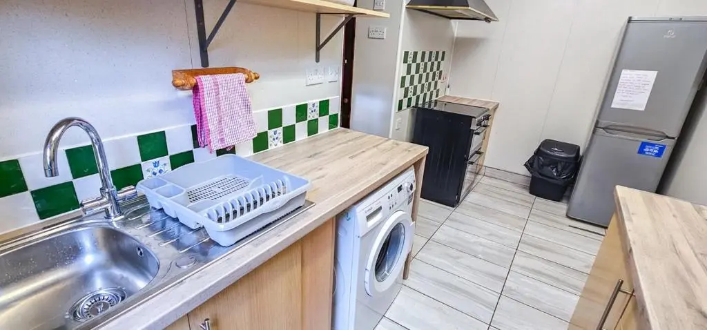 a kitchen with a sink and a washing machine at mySTAYINN Melrose Villa in Inverness