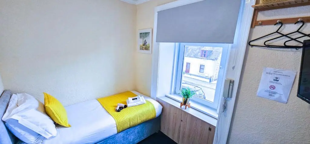 a small room with a bed and a window at mySTAYINN Telford Guest House in Inverness