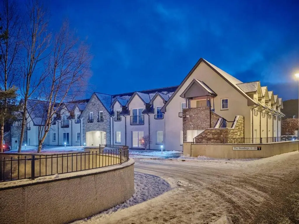 a row of houses in the snow at night at The Steadings, Aviemore Luxury 5 star rated 3 Bed with home cinema garden and parking in Aviemore