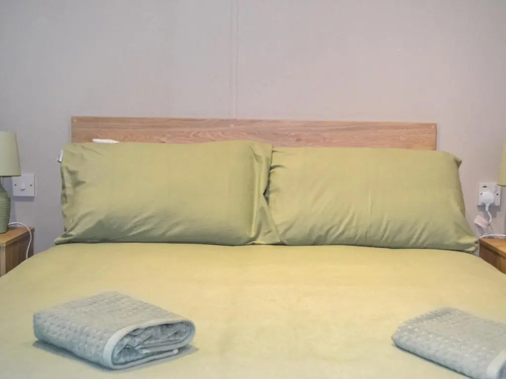 a bed with two pillows and two towels on it at The Finch in Dyke