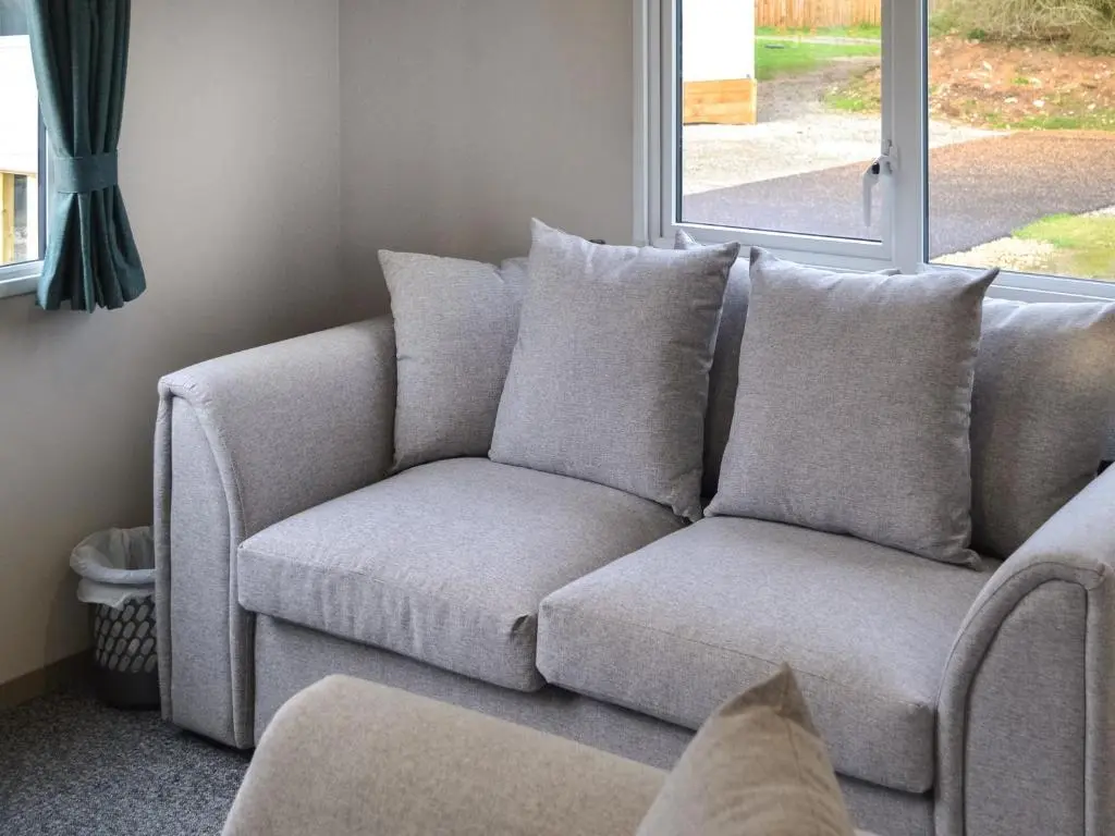 a grey couch in a living room with a window at The Falcon - Uk45538 in Dyke