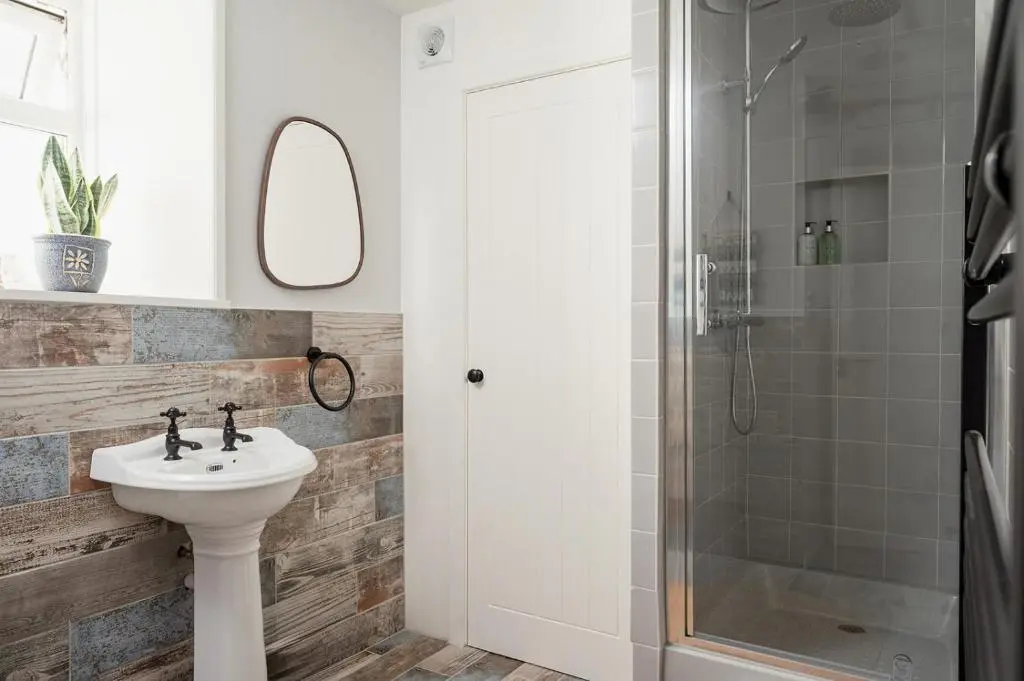 a bathroom with a sink and a shower at Ina's Cottage - Seasgair Lodges in Portmahomack