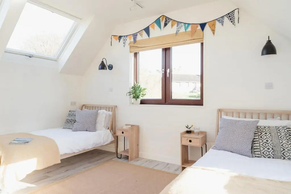 a bedroom with two beds and a window at Ina's Cottage - Seasgair Lodges in Portmahomack