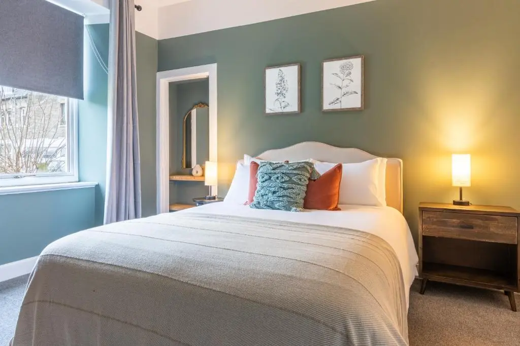 a bedroom with a large white bed with pillows at The Wee Gem in Inverness