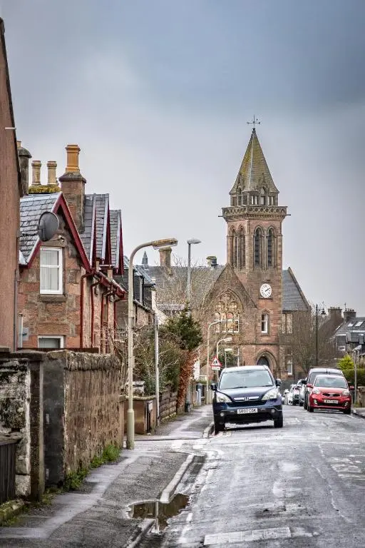 a car parked on a street in front of a church at The Wee Gem in Inverness