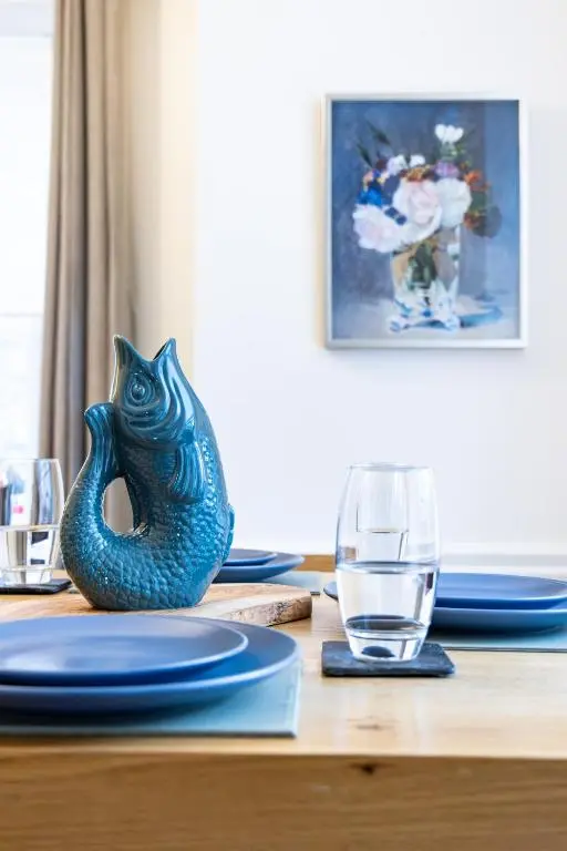 a table with blue plates and a glass on it at The Wee Gem in Inverness