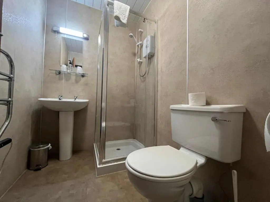 a bathroom with a toilet and a shower and a sink at Smithton Hotel in Inverness