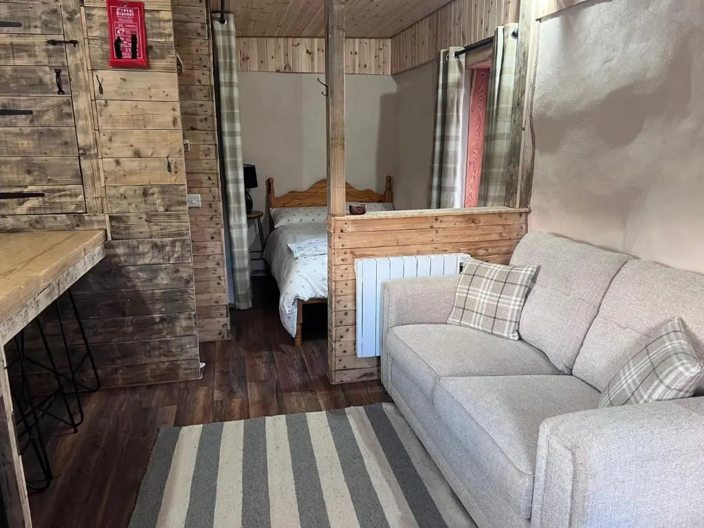 a living room with a couch and a bed at Willow Straw Bale Cabin