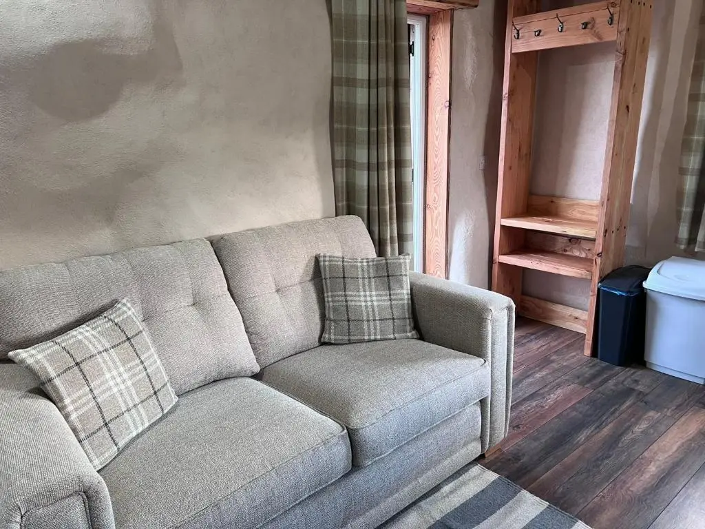 a couch and a chair in a living room at Willow Straw Bale Cabin