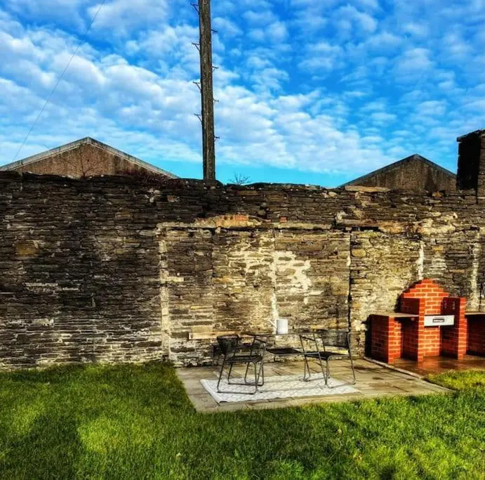two chairs and a table in front of a brick wall at GWR Dickson's House, NC500, Wick in Wick