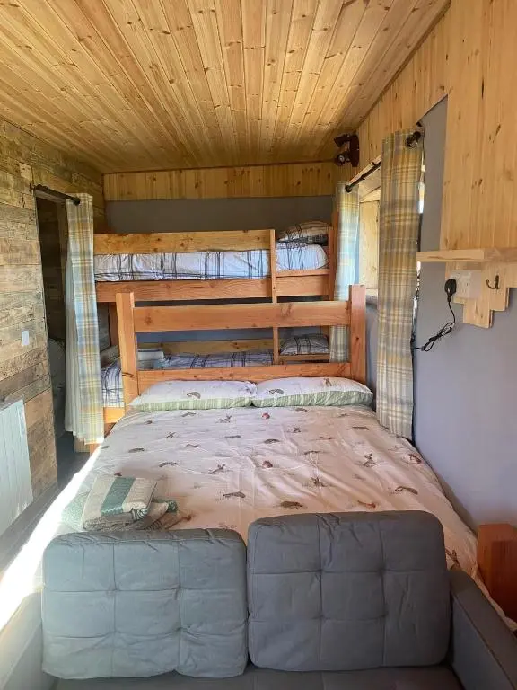 a bed in the middle of a room at Honeysuckle Straw Bale Cabin