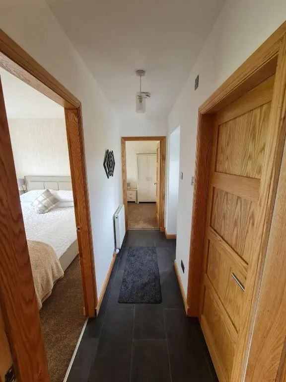 a bedroom with a bed and a large wooden door at Bruxie Holiday Cottages - River Cottage in Maud
