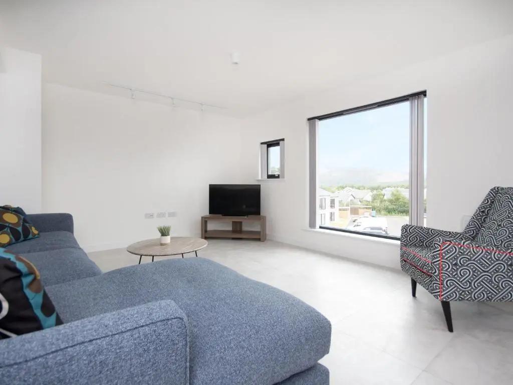 a living room with two blue couches and a tv at Caledonia View in Aviemore