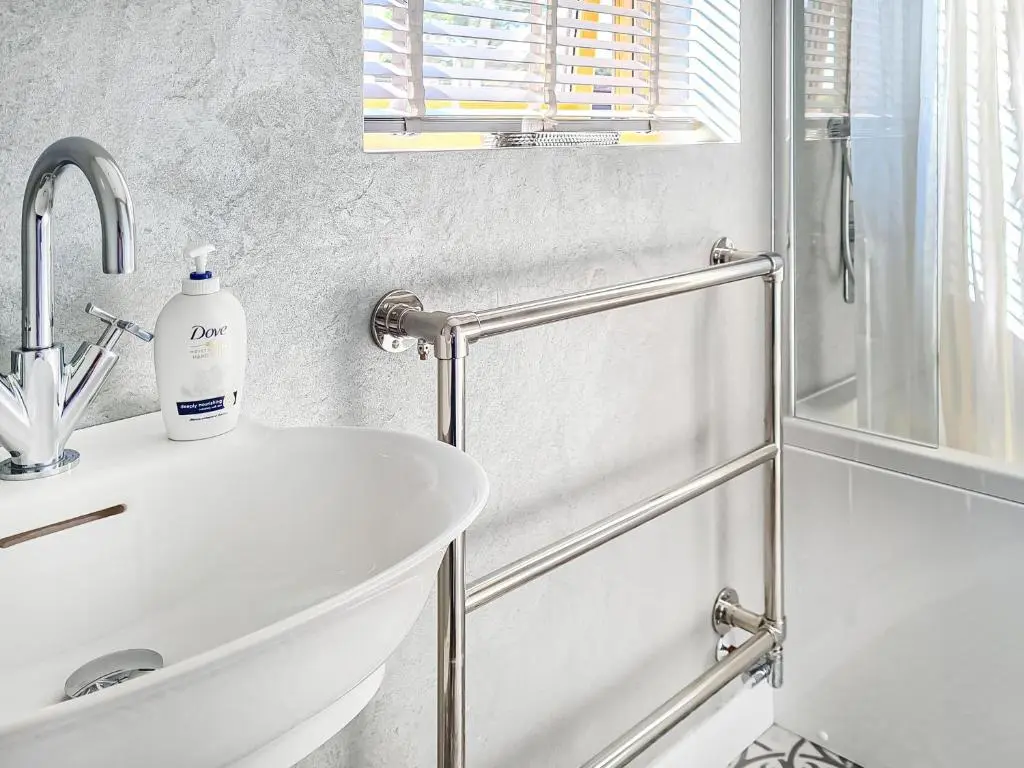 a white bathroom with a sink and a shower at Y Bwthyn in Culbokie