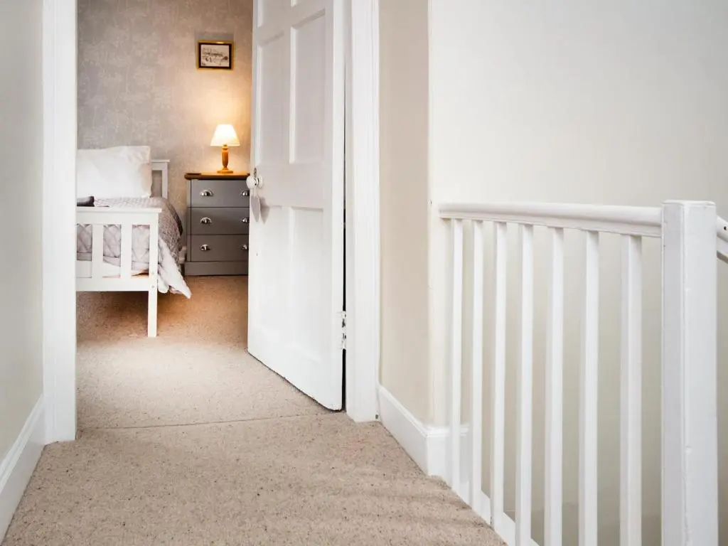 a bedroom with a bed and a white door at Solus Na Madainn in Tain