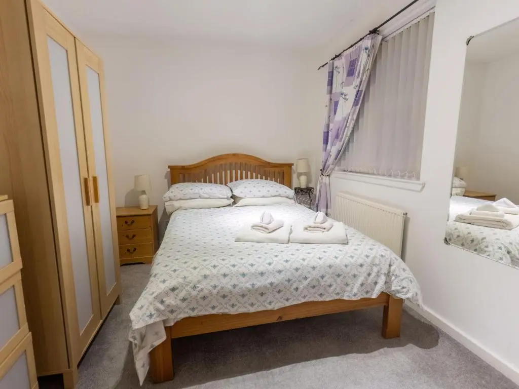 a bedroom with a bed with two towels on it at Villa Cedar House by Interhome in Inverness