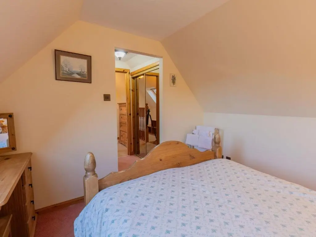 a bedroom with a wooden bed in a room at Holiday Home Lodge Road by Interhome in Inverness