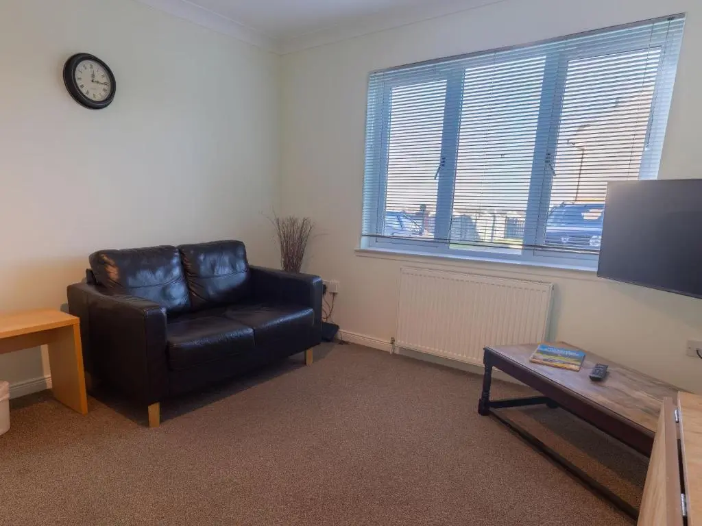 a living room with a black leather chair and a table at Apartment Ash House by Interhome in Inverness