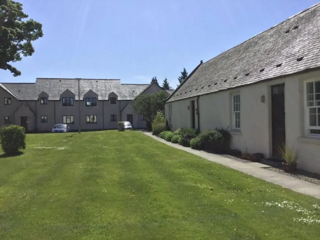 a row of houses with a grass yard at Apartment Old Edinburgh Cottage by Interhome in Inverness