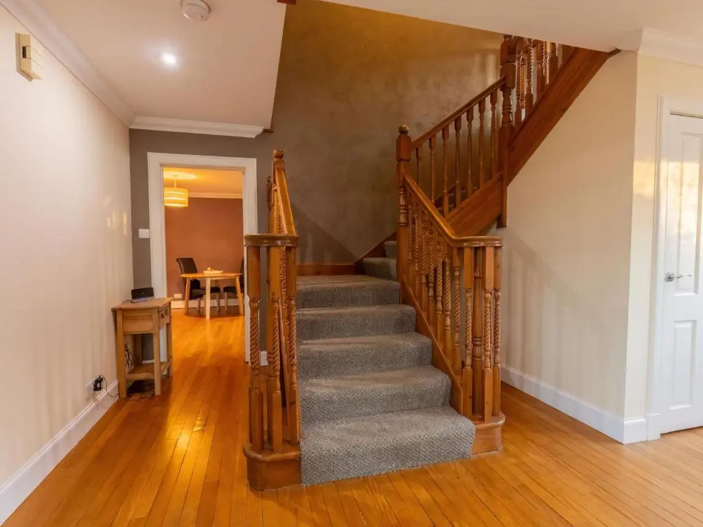 a winding staircase in a home with wooden floors at Villa Evergreen House by Interhome in Inverness