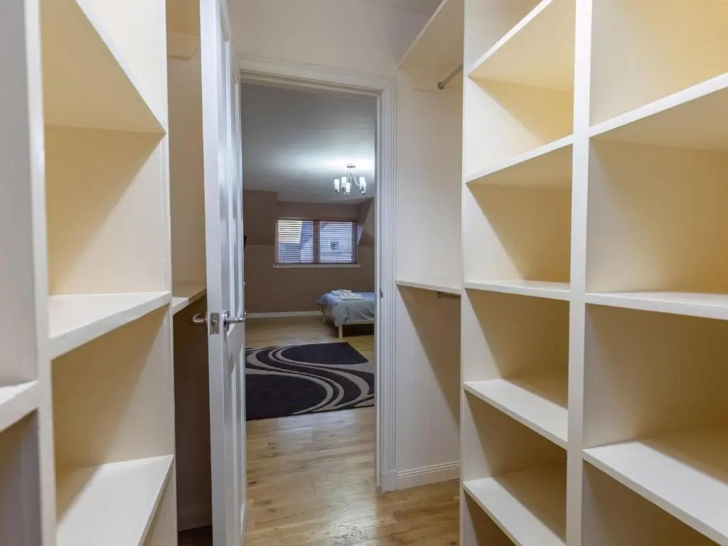 a walk in closet with white shelves at Villa Evergreen House by Interhome in Inverness