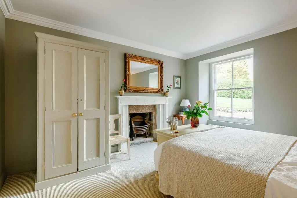 a bedroom with a bed and a mirror and a fireplace at Manar House Ground Floor Luxury Apartment in Inverurie