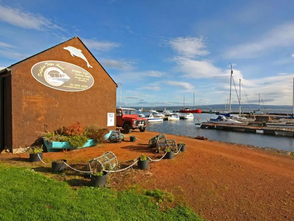 a building with a sign on it next to a marina at The Old Chandlery in Avoch