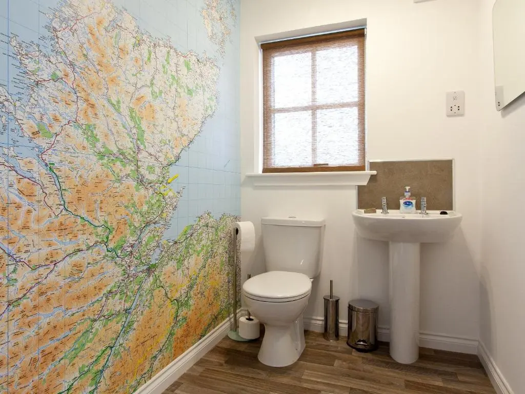 a bathroom with a toilet and a map on the wall at Mackay Road - Uk7451 in Dornoch