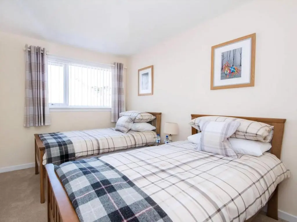a bedroom with two beds and a window at Raasay in Dornoch