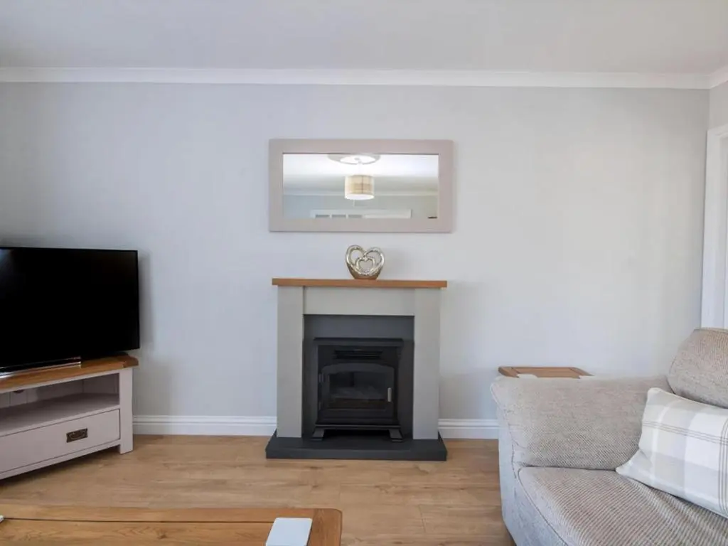a living room with a couch and a fireplace at Raasay in Dornoch