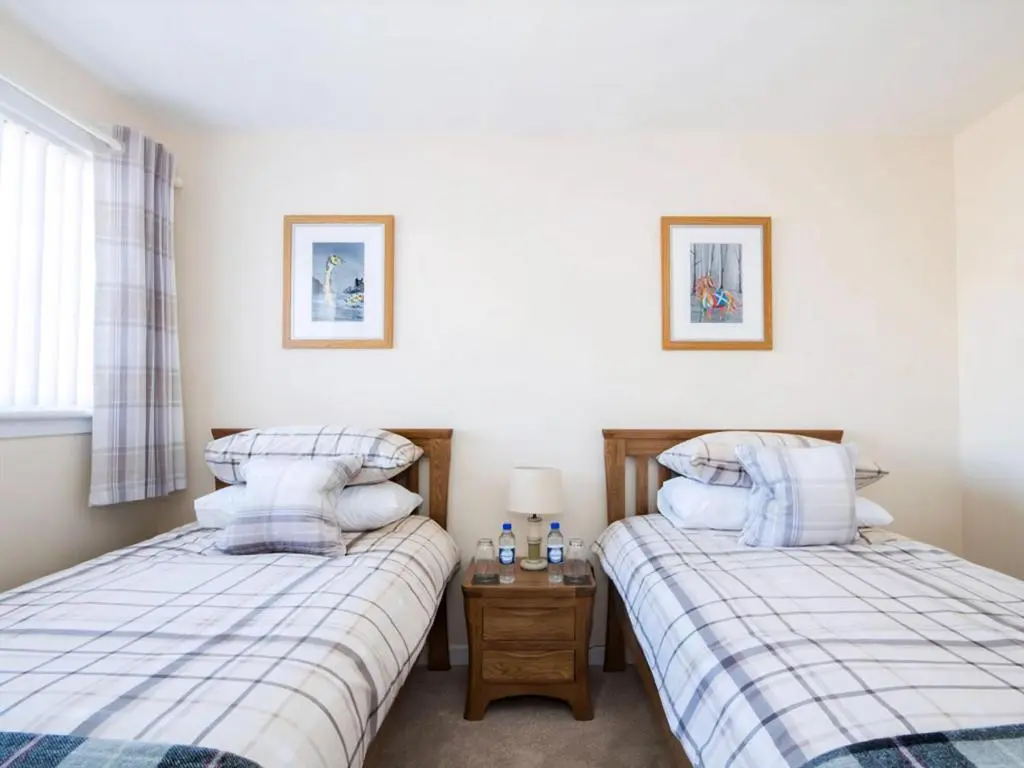a bedroom with two beds and a window at Raasay in Dornoch