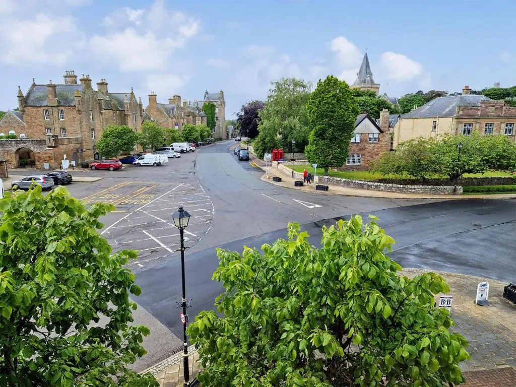 an empty street in a town with parked cars at Bird's Eye View in Dornoch