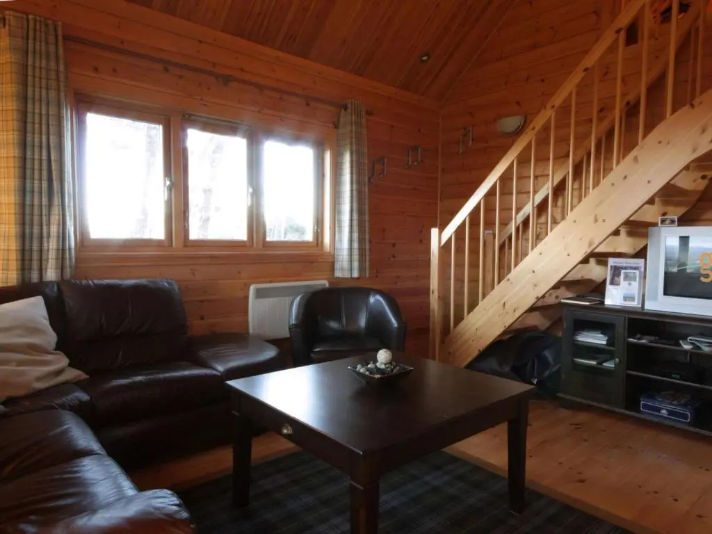 a living room with a couch and a coffee table at Taigh Fiodha in Balintore