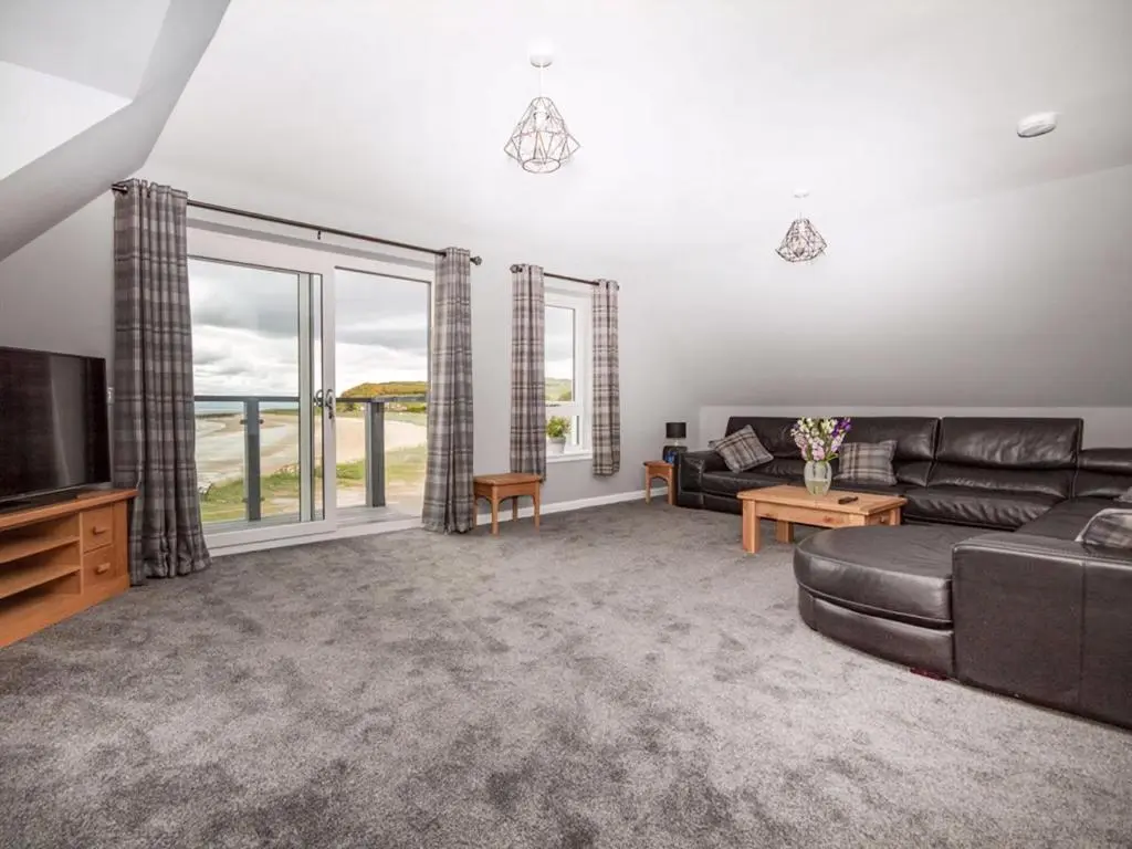 a living room with a couch and a tv at On The Beach-Uk7465 in Balintore