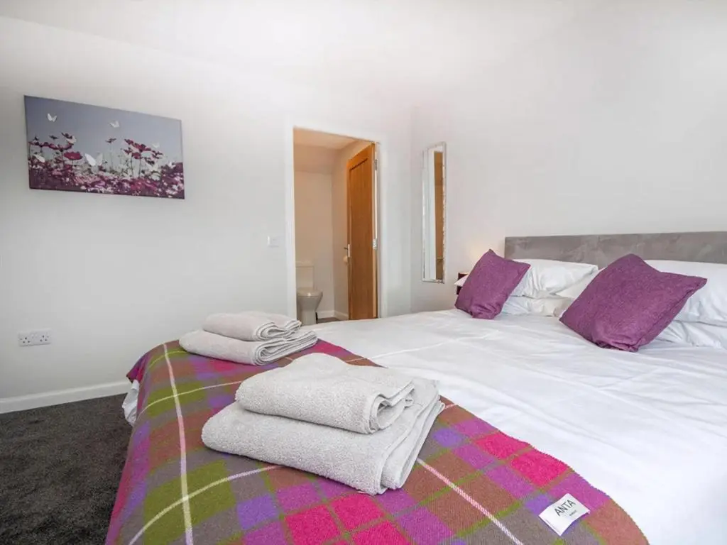 a bedroom with two beds with towels on them at On The Beach-Uk7465 in Balintore