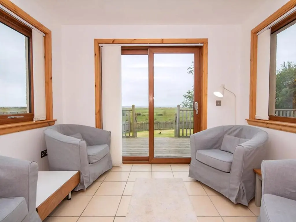 two chairs and a table in a room with a window at Lower Whinhill in Evelix