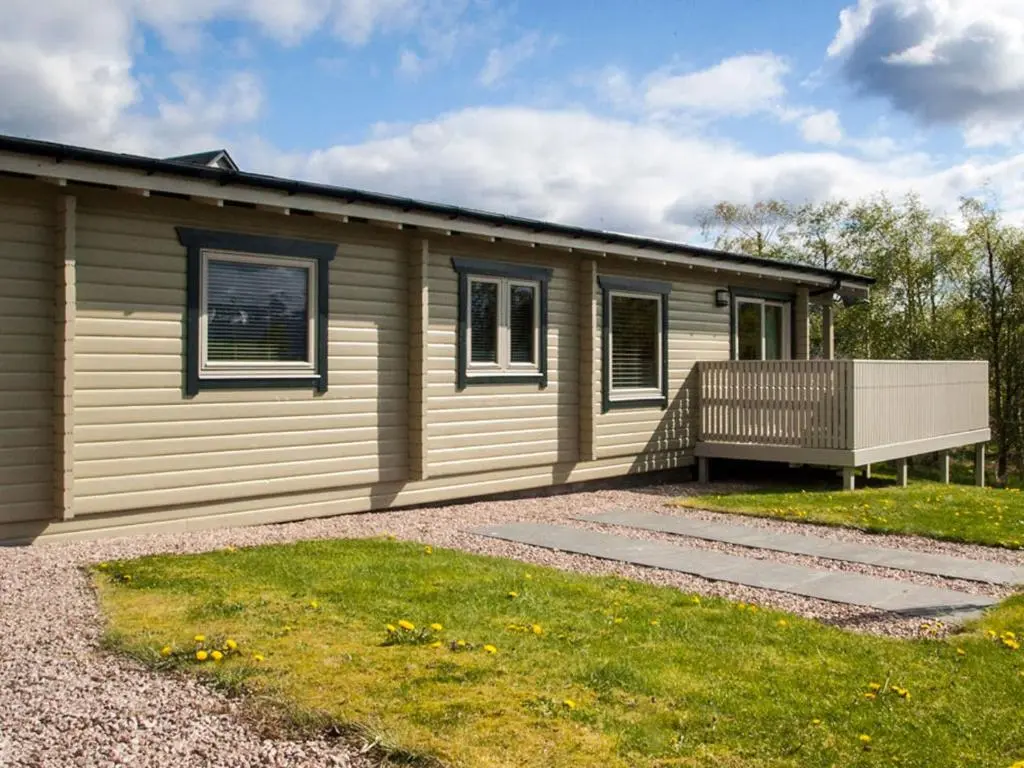 a small house with a porch and a deck at Carn Eilrig in Aviemore