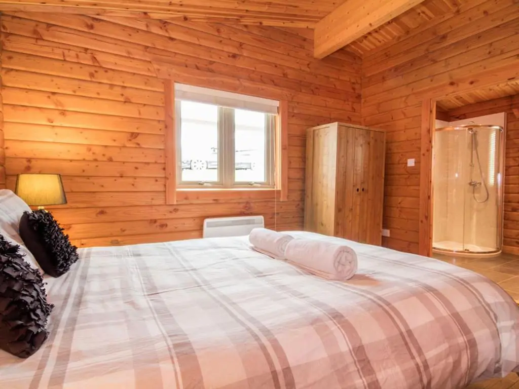 a bedroom with a bed in a wooden cabin at Carn Eilrig in Aviemore