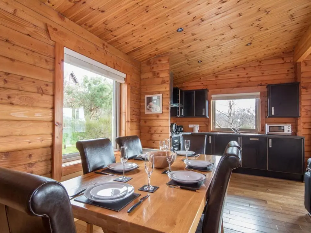 a dining room with a wooden table and chairs at Carn Eilrig in Aviemore