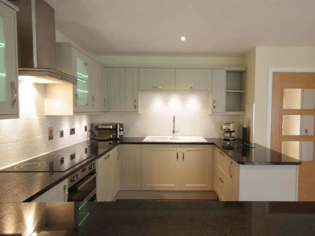 a kitchen with white cabinets and a sink at The Steading Apartment, No9 in Aviemore