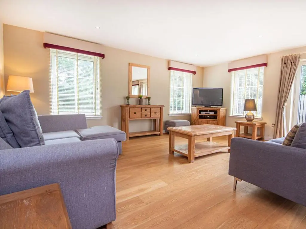 a living room with two couches and a tv at The Steading Apartment, No9 in Aviemore