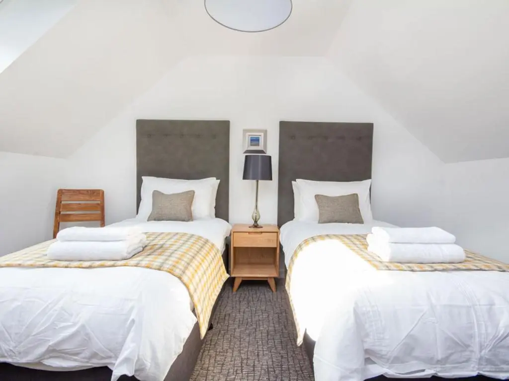 two beds sitting next to each other in a room at Oakwood in Aviemore