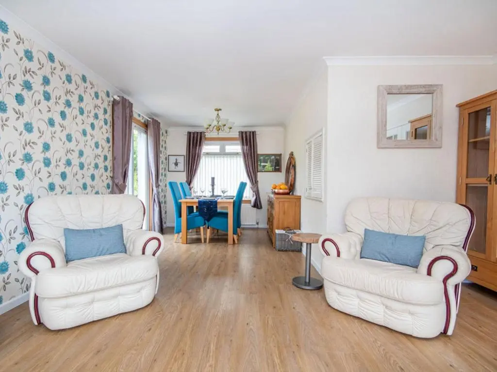 a living room with two chairs and a table at Caledon in Aviemore